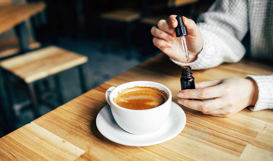 Woman Adding Distillate To Her Coffee